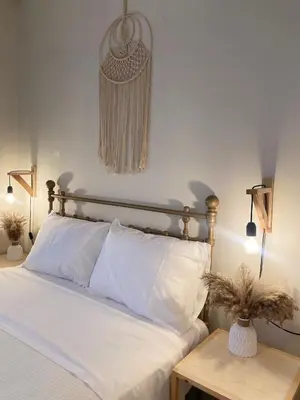 a bedroom with a bed with white sheets and a table at Bohemian Paradise Villa in Paradeísion