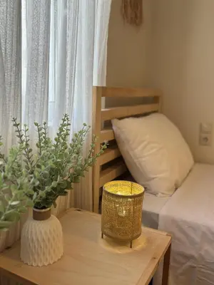 a small bedroom with a bed and a table with a vase at Bohemian Paradise Villa in Paradeísion