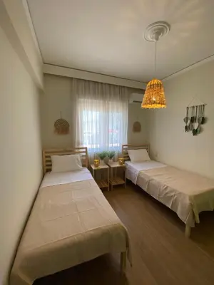 a bedroom with two beds and a chandelier at Bohemian Paradise Villa in Paradeísion
