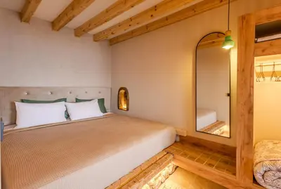 a bedroom with a bed with a large mirror at Diamond Seaview Stegna in Archangelos