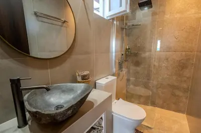 a bathroom with a sink and a toilet and a mirror at Diamond Seaview Stegna in Archangelos