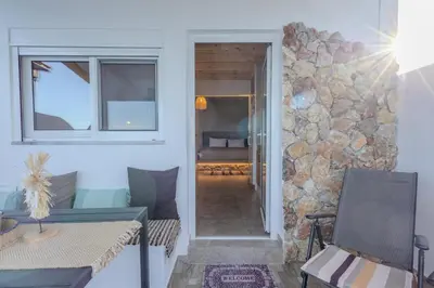 a hallway leading to a living room with a stone wall at Diamond Seaview Stegna in Archangelos