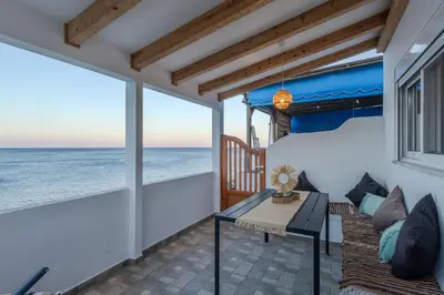 a bedroom with a bed and a view of the ocean at Diamond Seaview Stegna in Archangelos