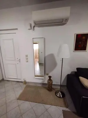 a living room with a couch and a mirror at Marias Apartment in Kolimbia