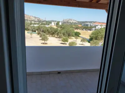 a room with a window with a view of a field at Marias Apartment in Kolimbia