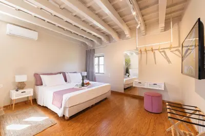 a bedroom with a large white bed and wooden floors at Ladino Old Town in Rhodes Town