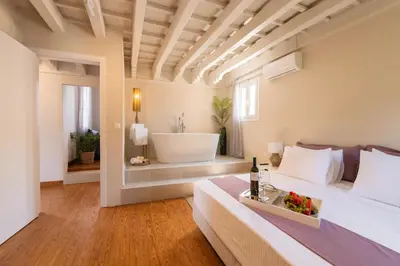 a bedroom with a tub and a bed with a sink at Ladino Old Town in Rhodes Town