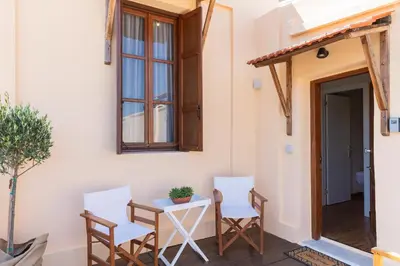 a patio with two chairs and a table and a window at Ladino Old Town in Rhodes Town