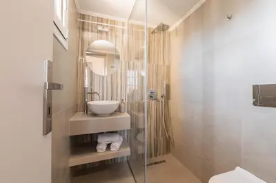 a bathroom with a sink and a toilet and a mirror at Ladino Old Town in Rhodes Town