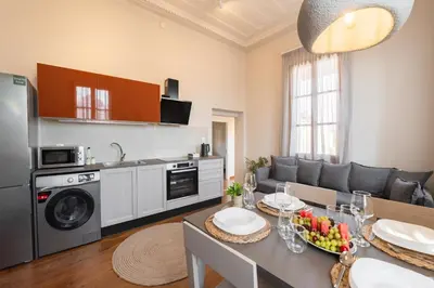 a kitchen and living room with a table and a dining room at Ladino Old Town in Rhodes Town