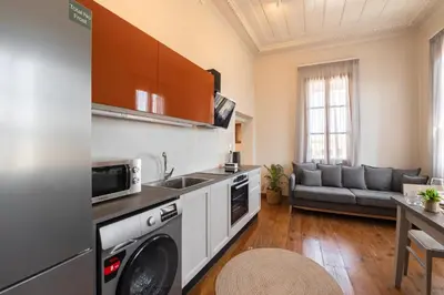 a kitchen with a washer and dryer and a living room at Ladino Old Town in Rhodes Town