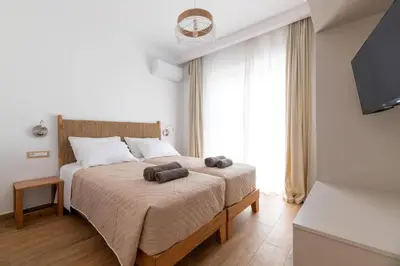 a bedroom with a bed with two towels on it at Villa Dana by Villa Plus in Ialyssos