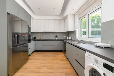 a kitchen with white cabinets and a washer and dryer at Villa Dana by Villa Plus in Ialyssos
