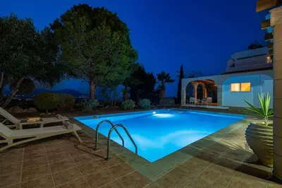 a swimming pool in a backyard at night at Villa Lavanda, panoramic view! in Kalathos