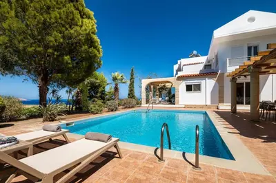 a villa with a swimming pool in front of a house at Villa Lavanda, panoramic view! in Kalathos