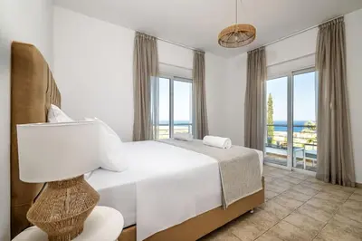 a bedroom with a bed and a view of the ocean at Villa Lavanda, panoramic view! in Kalathos