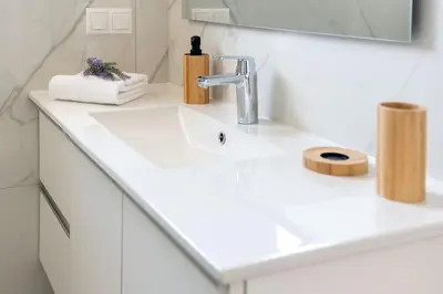 a white bathroom sink with a faucet and a mirror at Villa Lavanda, panoramic view! in Kalathos