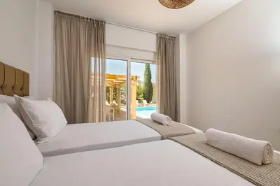 two beds in a bedroom with a view of a pool at Villa Lavanda, panoramic view! in Kalathos