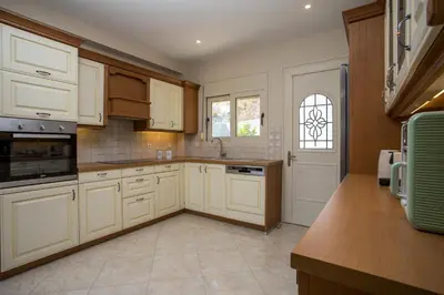 a kitchen with white cabinets and a window at Escape In View Villa Rhodes in Pastida