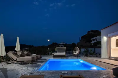 a swimming pool in a backyard at night at Escape In View Villa Rhodes in Pastida