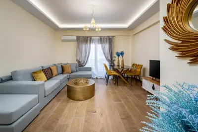 a living room with a blue couch and a table at J O House in Archangelos
