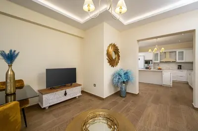 a living room with a television and a kitchen at J O House in Archangelos