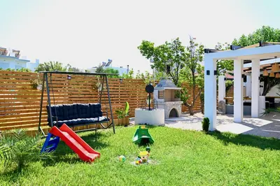 a backyard with a playground with a slide at Harmony Garden House in Ialyssos