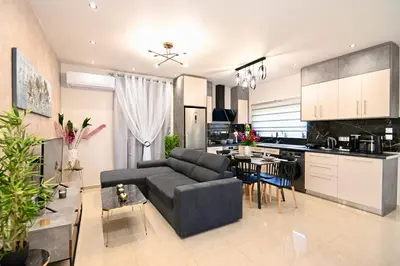 a living room and kitchen with a couch and a table at Harmony Garden House in Ialyssos
