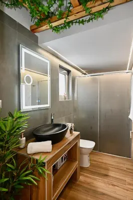 a bathroom with a black sink and a toilet at Harmony Garden House in Ialyssos