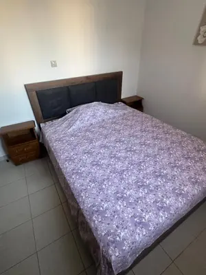 a bed with a purple blanket on top of it at KakLeCharaki in Haraki