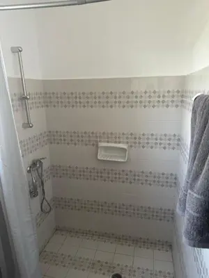 a bathroom with a shower with a scale on it at KakLeCharaki in Haraki