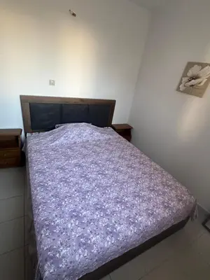 a bedroom with a bed with a purple comforter at KakLeCharaki in Haraki