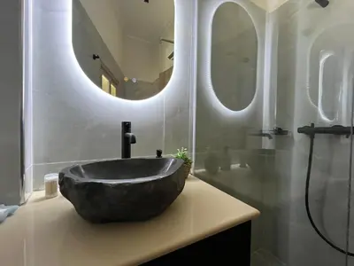 a bathroom with a large stone sink and two mirrors at Mirodaty's House in Rhodes Town
