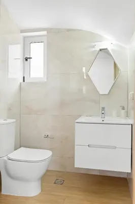 a white bathroom with a toilet and a sink at Le Palme Beach Rhodes in Haraki