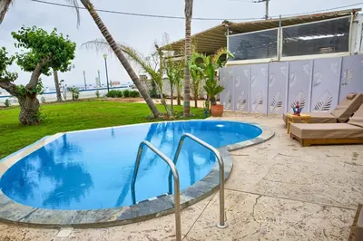a swimming pool in front of a house at Le Palme Beach Rhodes in Haraki