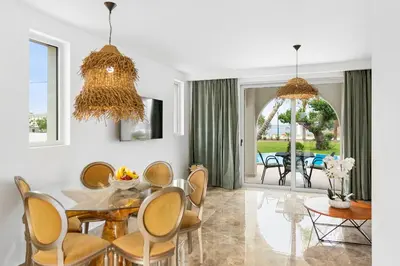 a dining room with a table and chairs at Le Palme Beach Rhodes in Haraki