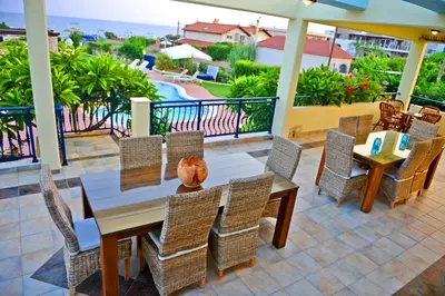 a patio with a table and chairs and a view of the ocean at Villa Angelina in Pefki Rhodes