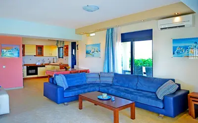 a living room with a blue couch and a table at Villa Angelina in Pefki Rhodes