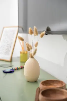 a white vase with feathers in it sitting on a desk at CasaVerde Central Apartment in Rhodes Town