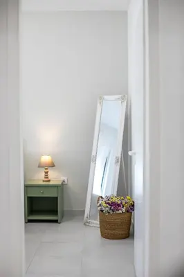 a room with a mirror and a basket of flowers at CasaVerde Central Apartment in Rhodes Town