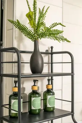 a shelf with three bottles of soap and a plant at CasaVerde Central Apartment in Rhodes Town