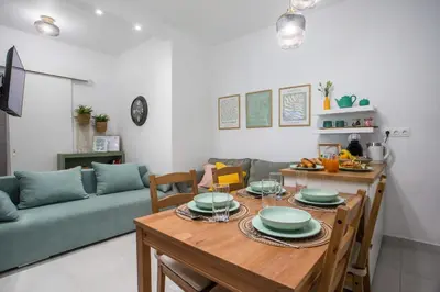 a living room with a table and a green couch at CasaVerde Central Apartment in Rhodes Town
