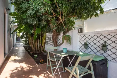 a table and chairs next to a tree on a sidewalk at CasaVerde Central Apartment in Rhodes Town