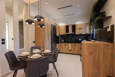 a kitchen and dining room with a table and chairs at Kallithea Blue in Koskinou