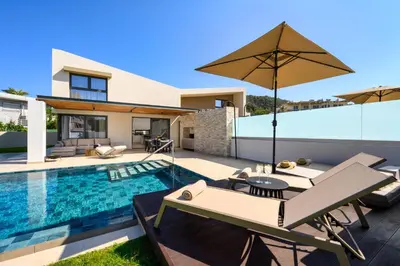 a villa with a swimming pool and a house at Alma Luxury Villas in Ialyssos