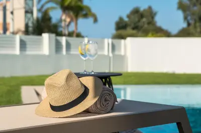 a straw hat sitting on a table with a wine glass at Alma Luxury Villas in Ialyssos
