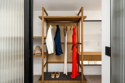 a closet with a wooden rack with clothes and shoes at Alma Luxury Villas in Ialyssos