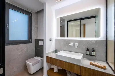 a bathroom with a sink and a mirror at Alma Luxury Villas in Ialyssos