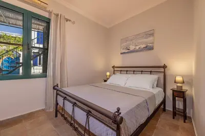 a bedroom with a bed and a window at Koskinou Residence in Koskinou
