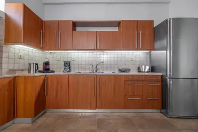 a kitchen with wooden cabinets and a stainless steel refrigerator at Koskinou Residence in Koskinou